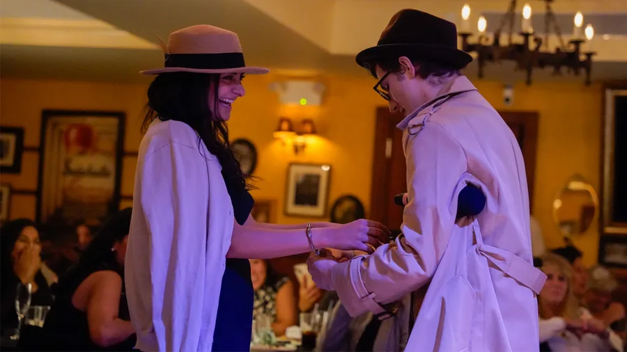 A Murder Mystery Company detective questioning a guest at a Washington show